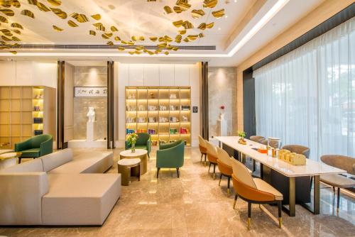 a restaurant with couches and tables and chairs at Atour Hotel Dongguan Humen Avenue in Dongguan