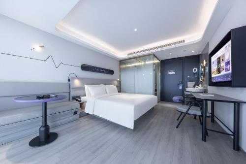 a hotel room with a bed and a flat screen tv at Atour Light Hotel Beijing Daxing Biomedical Base Metro Station in Daxing