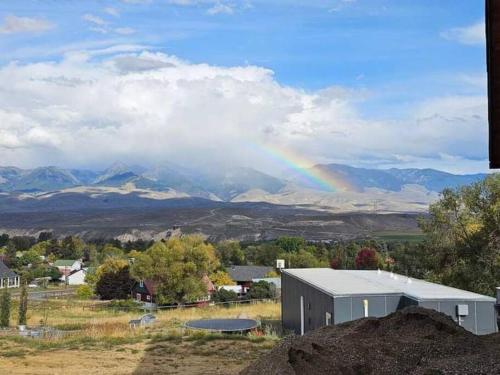 einen Regenbogen über einem Feld mit einem Gebäude und Bergen in der Unterkunft KarKens Container Home in Salmon