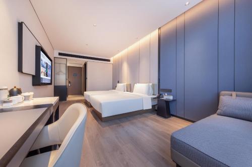 a hotel room with two beds and a couch at Atour Hotel Shenzhen Futian CBD Civic Center in Shenzhen