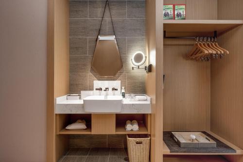 een badkamer met een wastafel en een spiegel bij Atour Hotel Xi'an International Port Area in Xi'an