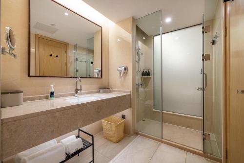 y baño con ducha, lavabo y espejo. en Atour X Hotel Shenzhen Baoan Airport Aviation City, en Bao'an