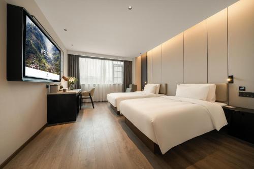 a hotel room with two beds and a flat screen tv at Atour Hotel Chongqing Bishan CBD Financial Street in Daxing