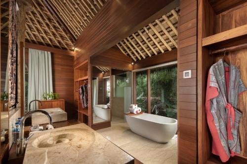 a bathroom with a tub and a sink and a bath tub at Lelewatu Resort Sumba in Watukarere