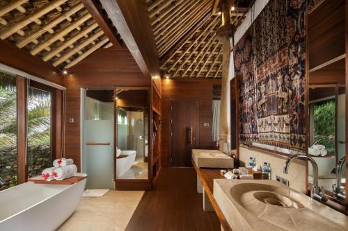 a bathroom with two sinks and a tub at Lelewatu Resort Sumba in Watukarere