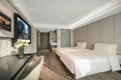 成都市にあるAtour Hotel Chengdu Wuhou West Intelligent Valleyのベッド2台とテレビが備わるホテルルームです。