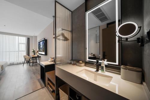 een badkamer met een wastafel en een spiegel bij Atour Hotel Chengdu Dujiangyan Darong City in Dujiangyan