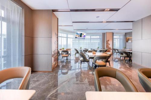 a dining area with tables and chairs in a lobby at Atour S Hotel Beijing Daxing International Airport in Daxing