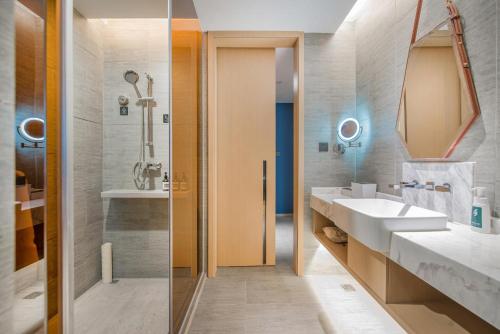 a bathroom with two sinks and a mirror at Atour Hotel Guangzhou Sanyuanli-Guangzhou Baiyun Railway-Fiee Self-Service Laundry in Guangzhou