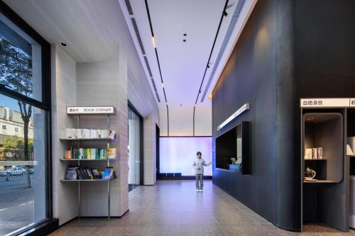 a person walking down a hallway in a building at Atour Light Hotel Guangzhou East Fuhua Road Panyu Plaza in Guangzhou