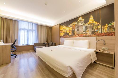 a hotel room with a large bed and a desk at Atour Hotel Xujiahui Meiying in Shanghai