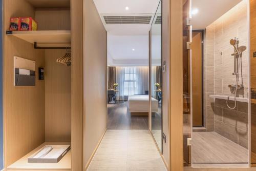 a hallway leading to a room with a bathroom at Atour Hotel Zhijiang Bridge in Hangzhou