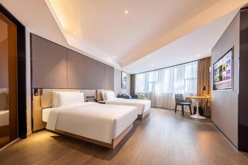 a hotel room with two beds and a desk at Atour Hotel Chongqing North Railway Station in Chongqing