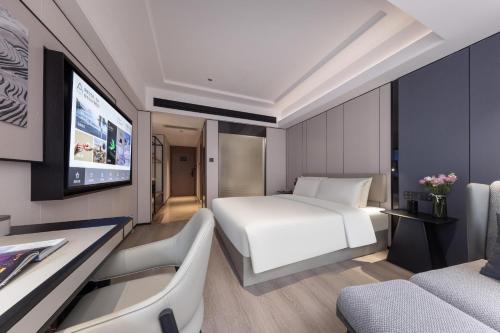 a hotel room with a bed and a tv at Atour X Hotel Shenzhen Luohu Sungang Baoneng Center in Shenzhen