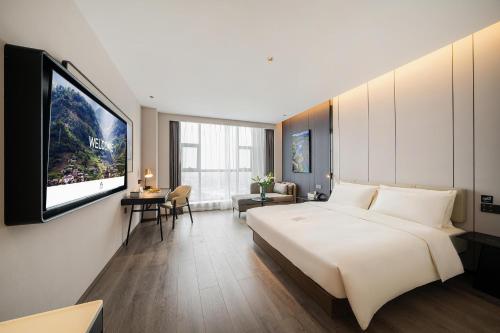 um quarto com uma cama grande e uma televisão de ecrã plano em Atour Hotel Chengdu Dujiangyan Darong City em Dujiangyan