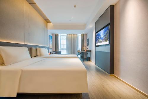 a bedroom with two beds and a flat screen tv at Atour Hotel Dongguan Humen Avenue in Dongguan