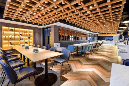 a restaurant with wooden ceilings and tables and chairs at Atour Hotel Chengdu Jinli Hongpailou Subway Station in Chengdu