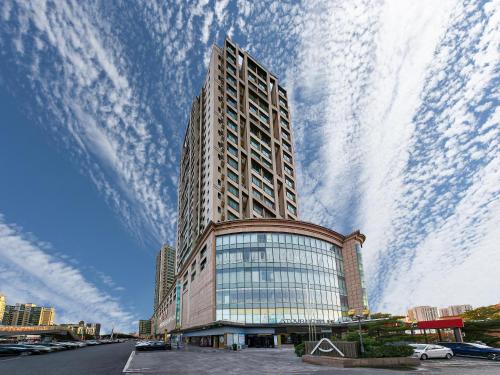 a tall building with a cloudy sky behind it at Atour Hotel Beijing Tongzhou Liyuan Subway Station in Tongzhou