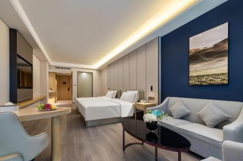 Habitación de hotel con cama y sofá en Atour X Hotel Shenzhen Baoan Airport Aviation City, en Bao'an