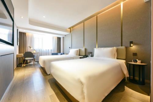 a hotel room with two beds and a desk at Atour Hotel Beijing Tongzhou Liyuan Subway Station in Tongzhou
