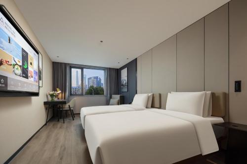 a hotel room with two beds and a flat screen tv at Atour Hotel Shanghai Lujiazui South Pudong Road in Shanghai