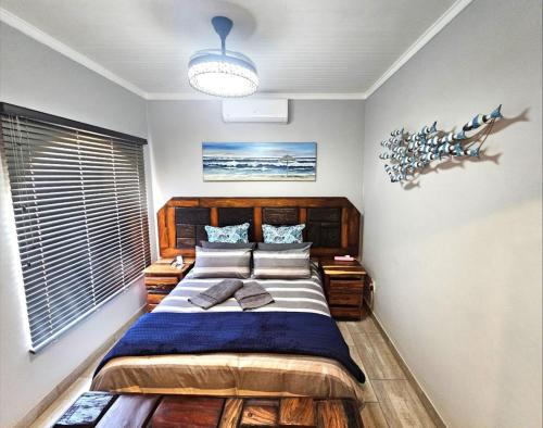 a bedroom with a large bed with a wooden headboard at De Oude Sleeper Inn 3 in Kimberley
