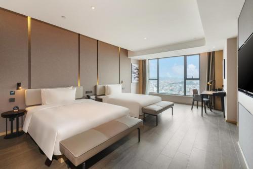 een hotelkamer met 2 bedden en een bureau bij Atour Hotel Dongguan Fenggang in Qinglinjing