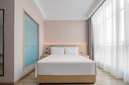 a bedroom with a white bed and a large window at Atour X Hotel Chengdu Longquan Automobile City in Chengdu