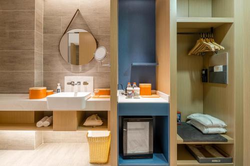 a bathroom with a sink and a mirror at Atour Hotel Hangzhou Qianjiang Century City International Expo Center in Xiaoshan