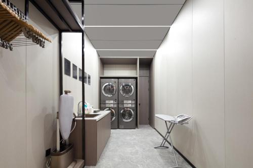 a laundry room with two washers and a sink at Atour Hotel Xiamen Xiang'an Torch Industrial Park in Xiang'an