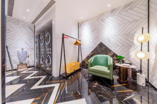 a lobby with a green chair and a wall at Atour S Hotel Beijing Daxing International Airport in Daxing