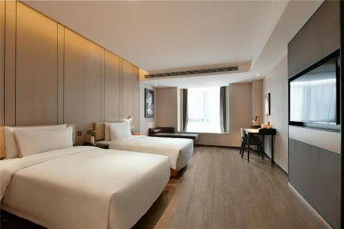 una camera d'albergo con due letti e una scrivania di Atour Hotel Chengdu High-Tech a Chengdu