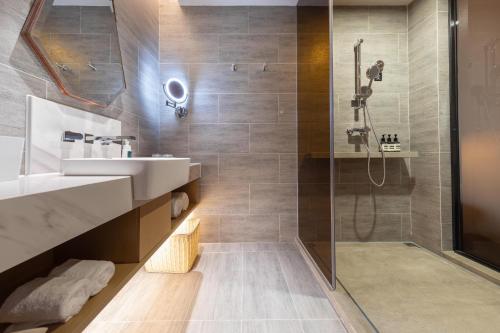 La salle de bains est pourvue d'un lavabo et d'une douche. dans l'établissement Atour Hotel Shenzhen Guangming New City, à Shenzhen