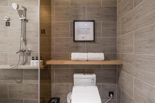 a bathroom with a shower and a toilet in it at Atour Hotel Hangzhou West Lake Wulin Plaza North Jianguo Road in Hangzhou