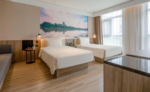 a hotel room with two beds and a large window at Atour Hotel Xi'an West Erhuan Road Tai'ao in Xi'an