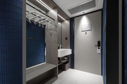 y baño con lavabo y espejo. en Atour Light Hotel Hangzhou West Lake Huanshan Road en Hangzhou