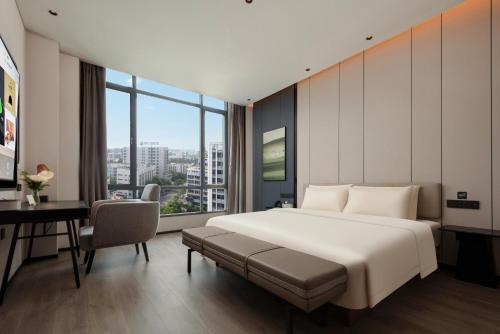 a hotel room with a large bed and a desk at Atour Hotel Foshan Chancheng Zhangcha in Foshan