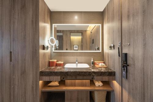 ein Bad mit einem Waschbecken und einem Spiegel in der Unterkunft Atour Hotel Xi'an Daming Palace in Xi'an