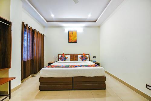 a bedroom with a large bed in a room at FabExpress Alaknanda Paradise in Dehradun