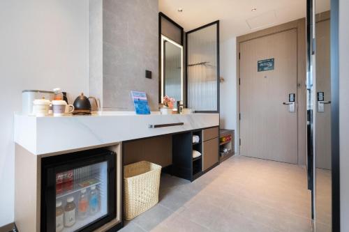 a kitchen with a counter and a refrigerator at Atour Hotel Kunming Railway Station Joy City in Kunming