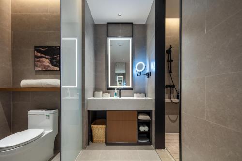 a bathroom with a sink and a toilet and a mirror at Atour Hotel Foshan Chancheng Zhangcha in Foshan