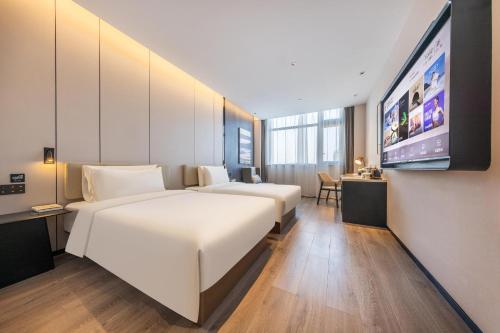 蕭山的住宿－杭州萧山火车南站萧绍路亚朵酒店，酒店客房设有两张床和一台平面电视。