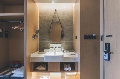 y baño con lavabo y espejo. en Atour Hotel Zhanjiang Renmin Avenue Dingsheng Plaza, en Zhanjiang