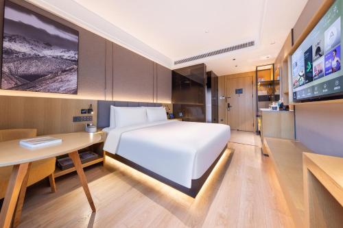 北京的住宿－北京马家堡地铁站亚朵X酒店，一间卧室配有一张床、一张书桌和一台电视。