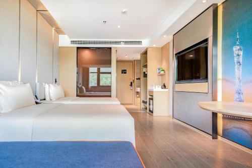 廣州的住宿－广州黄埔萝岗科学城亚朵酒店，酒店客房设有两张床和一台平面电视。