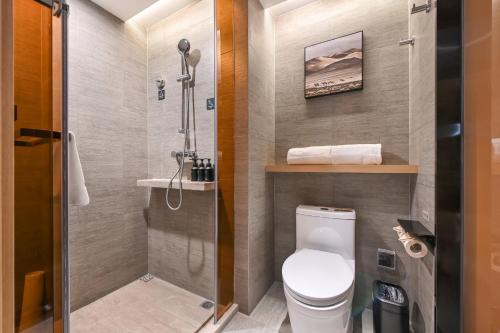 a small bathroom with a toilet and a shower at Atour Hotel Beijing Drum Tower in Beijing