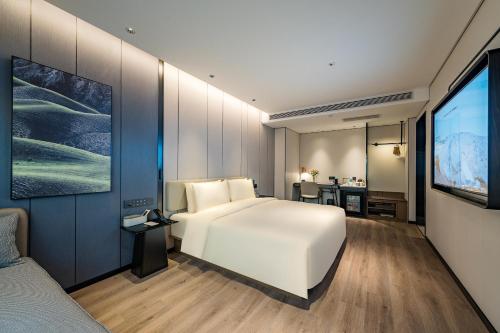 a bedroom with a white bed and a flat screen tv at Atour Hotel Beijing Temple of Heaven Zuo'anmen Gate in Beijing