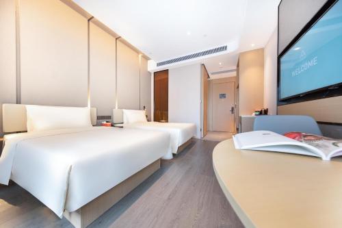 Ένα ή περισσότερα κρεβάτια σε δωμάτιο στο Atour Hotel Guangzhou South High-speed Railway Station