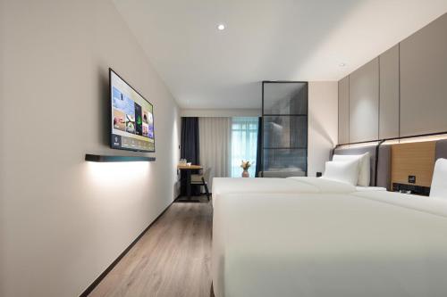 a hotel room with two beds and a flat screen tv at Atour X Hotel Shanghai Xujiahui Sports Center in Shanghai