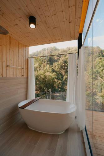 a bath tub in a room with a large window at Morning Star Glamping in Ban Pok Nai